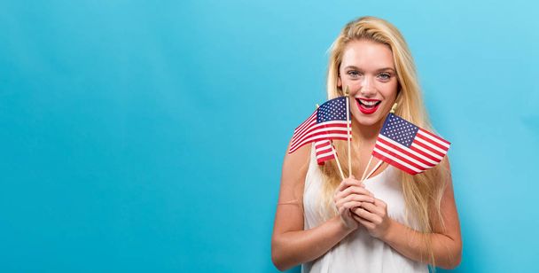 Happy young woman holding an American flag - Foto, Imagem