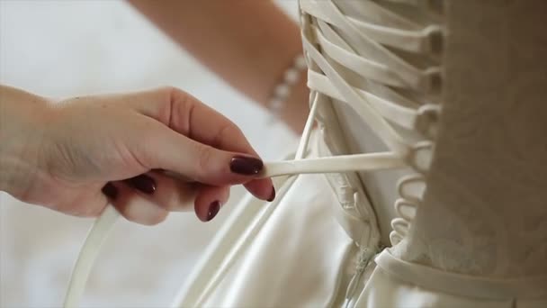 Mann bindet Brautkleid der Braut ein Korsett an - Filmmaterial, Video