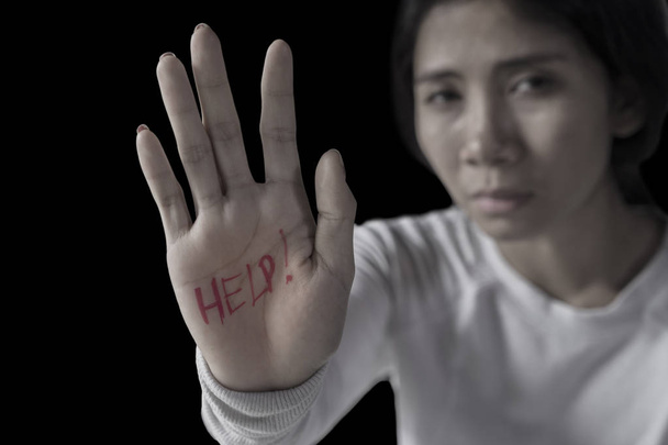 Image of lonely woman looks depressed while showing help word on her palm  - Fotoğraf, Görsel