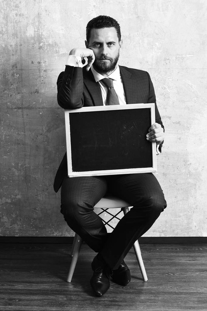 blackboard in hands of teacher man or businessman in suit - Foto, Imagen
