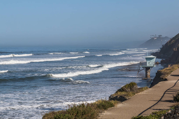 ein einsamer schwimmturm mit blick auf surfer am strand des staates san elijo in cardiff, kalifornien, gelegen im bezirk san diego. - Foto, Bild