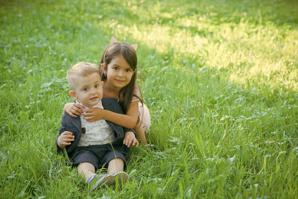 Счастливый ребенок веселится. Семья, дети, брат и сестра на зеленой траве
 - Фото, изображение