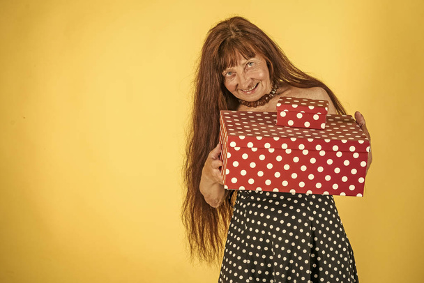 Woman with long red hair hold colorful box. - Foto, afbeelding