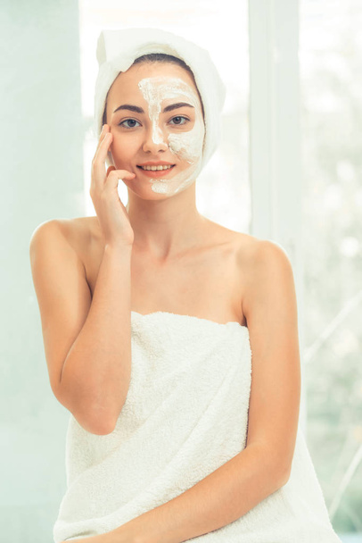 Mooie vrouw met een gezichtsverzorging cosmetische scrub behandeling van professionele dermatoloog bij wellness spa. Anti-aging, gezichtsverzorging en luxe lifestyle concept. - Foto, afbeelding