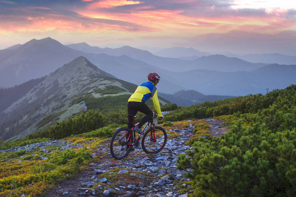 Δρομέας στο αλπικό πέτρινο μονοπάτι στα Καρπάθια με ένα ποδήλατο βουνού άνθρακα του ομίλου sports ως ένα σύμβολο της υγείας από το σύγχρονο τρόπο ζωής του ένα νεαρό άτομο προοδευτική - Φωτογραφία, εικόνα
