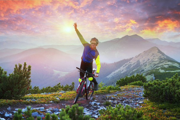Racer no caminho de pedra alpina nos Cárpatos com uma bicicleta de montanha de carbono do grupo esportivo como um símbolo da saúde do estilo de vida moderno de uma jovem pessoa progressiva
 - Foto, Imagem