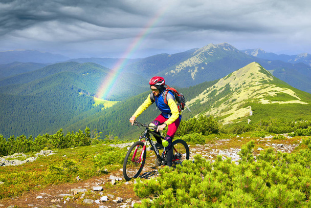 Racer op de Alpine stenen pad in de Karpaten met een carbon mountainbike van de groep van de sport als een symbool van de gezondheid van de moderne levensstijl van een progressieve jongere - Foto, afbeelding