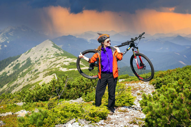 Corredor en el camino de piedra alpina en los Cárpatos con una bicicleta de montaña de carbono del grupo deportivo como símbolo de la salud del estilo de vida moderno de una persona joven progresiva
 - Foto, imagen