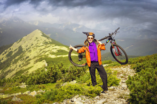 Racer on the Alpine stone path in the Carpathians with a carbon mountain bike of the sports group as a symbol of the health of the modern lifestyle of a young progressive person - Photo, Image