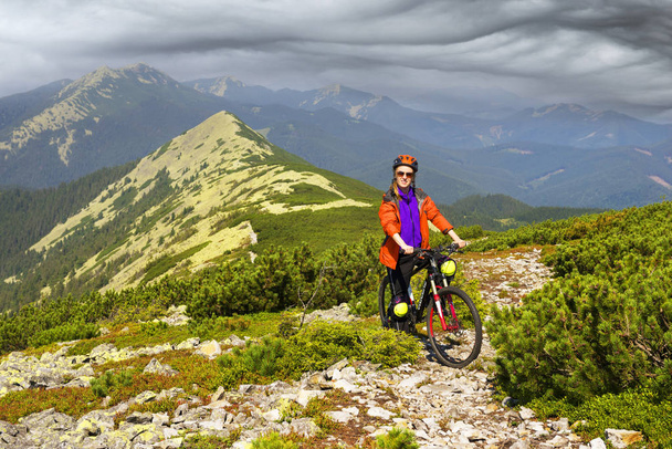 Racer op de Alpine stenen pad in de Karpaten met een carbon mountainbike van de groep van de sport als een symbool van de gezondheid van de moderne levensstijl van een progressieve jongere - Foto, afbeelding