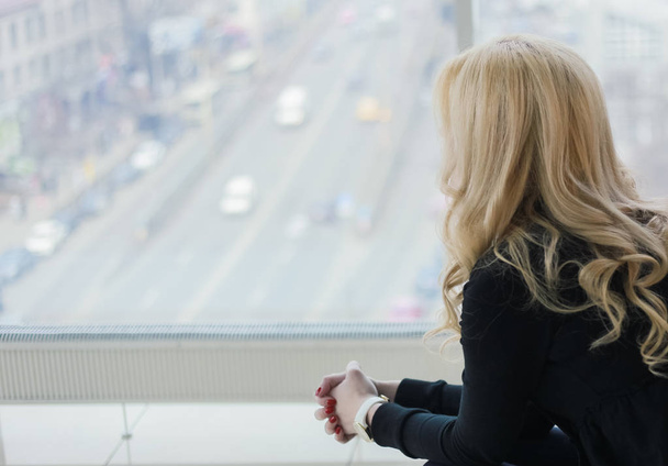 woman blonde in suit office worker in office with big window and view of the city - Φωτογραφία, εικόνα
