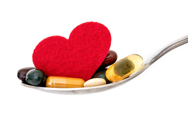 supplément médical coloré et pilules médicamenteuses avec coeur rouge dans la cuillère, médicaments de cardiologie pharmaceutique pour les maladies cardiaques concept de soins de santé
 - Photo, image