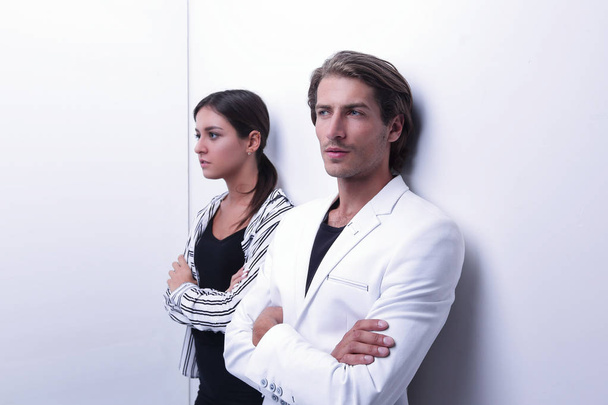 upset couple leaning on a white wall - Zdjęcie, obraz