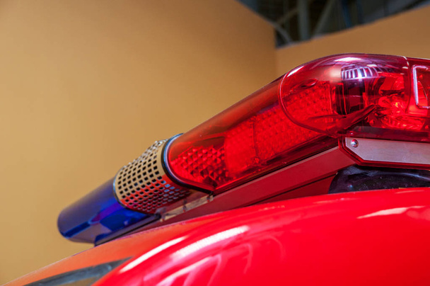 Червоно-блакитне попередження з довгою сиреною на даху автомобіля, що стоїть в гаражі, перетворило червону сторону крупним планом з розмитим тлом
 - Фото, зображення
