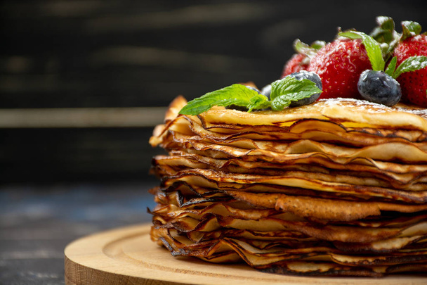 Stack of crepes, thin pancakes, russian bliny with strawberries - Photo, image