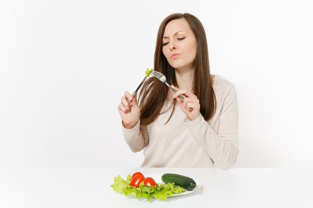 Vegan woman at table with leaves salad lettuce, vegetables on plate isolated on white background. Proper nutrition, vegetarian food, healthy lifestyle dieting concept. Advertising area to copy space - Фото, изображение