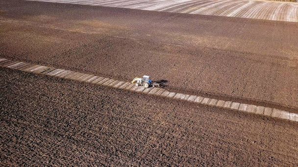 Трактор пашет поле удобрениями. Автумн, Россия
   - Фото, изображение