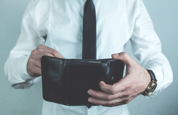 Businessman holding black leather wallet. - Foto, afbeelding
