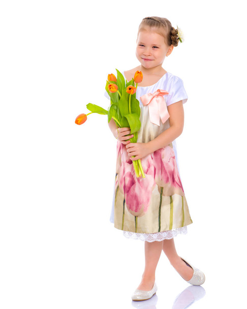 Little girl with a bouquet of tulips. - Fotoğraf, Görsel