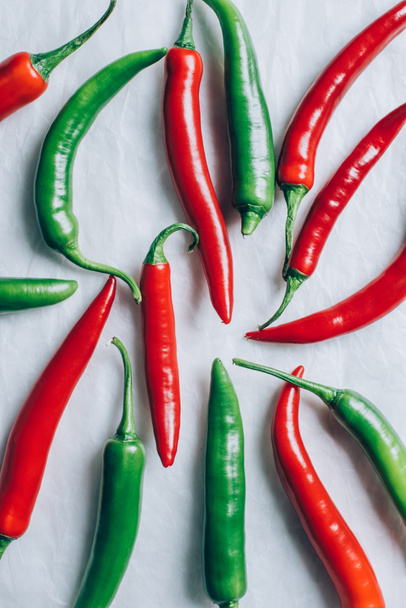 elevated view of red and green chili peppers on white surface - Фото, изображение