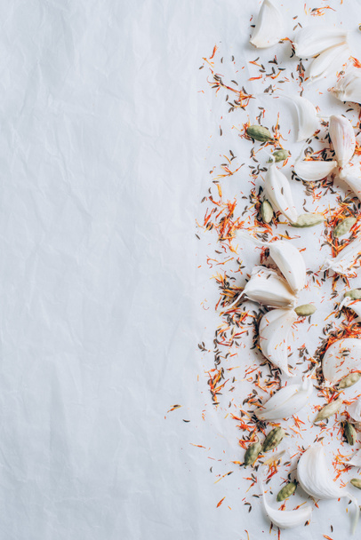 top view of scattered garlic and spices on white table - Photo, Image