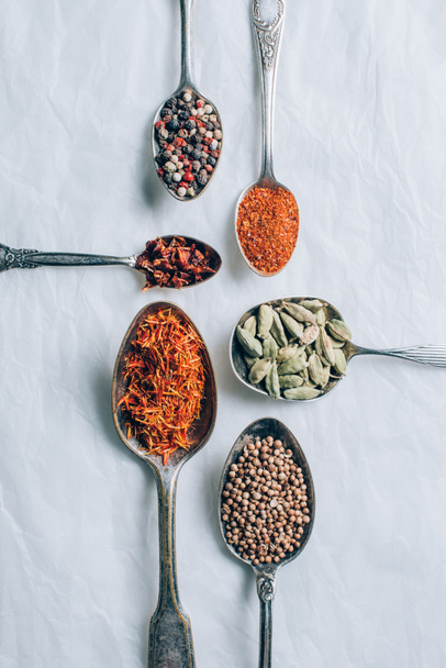 felülnézet indiai fűszerek, a kanál, a fehér asztal - Fotó, kép