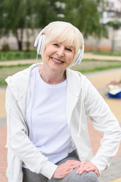 sorrindo mulher idosa ouvindo música em fones de ouvido
 - Foto, Imagem