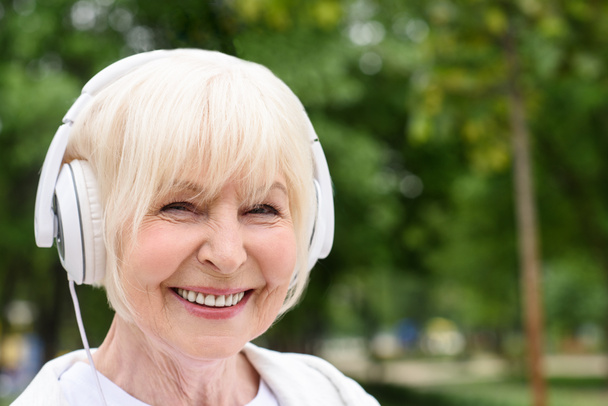 mulher sênior feliz ouvir música em fones de ouvido
 - Foto, Imagem