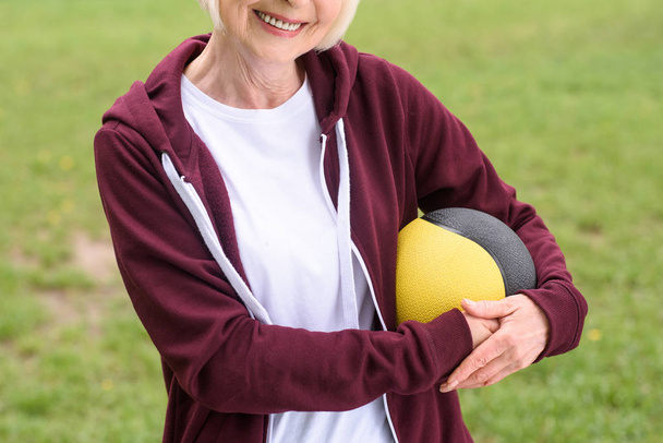 cropped view of senior sportswoman with medicine ball - 写真・画像