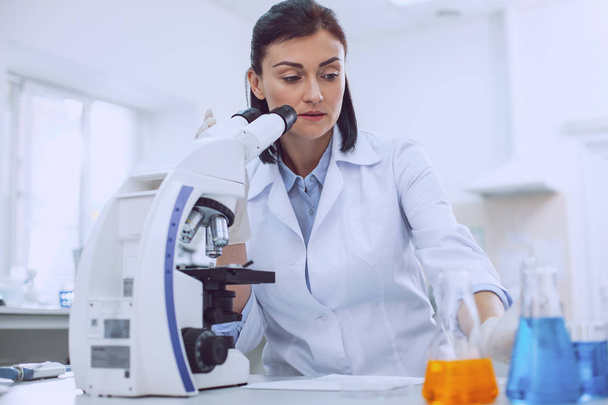 Professional female biologist working with a microscope - Фото, изображение