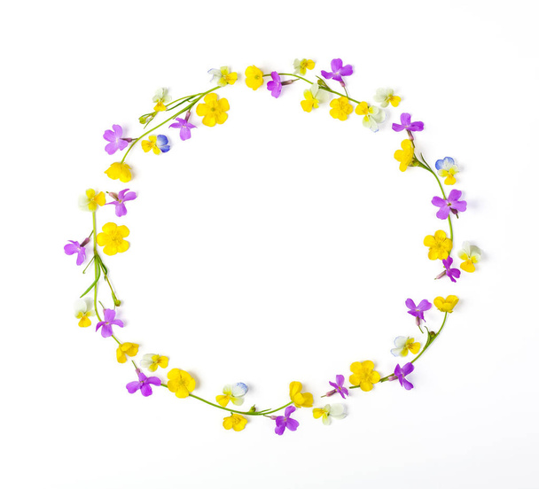 Round frame wreath made of meadow flowers isolated on white background. Top view. Flat lay. - Фото, зображення