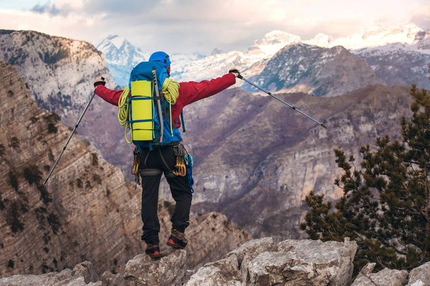 mountaineer standing with backpack on top of mountain and enjoying view - Photo, Image