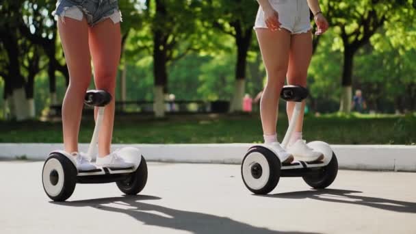 schöne wohlgeformte Beine junge Mädchen in kurzer Chertah Nahaufnahme auf weißem Gyrometer die elektrische Segway-Fahrt durch den Park - Filmmaterial, Video