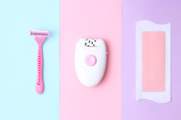 a set of means of hair removal. Wax strips, modern epilator and razor on a colored background. Minimalism, choice.top view, flatlay  - Фото, изображение