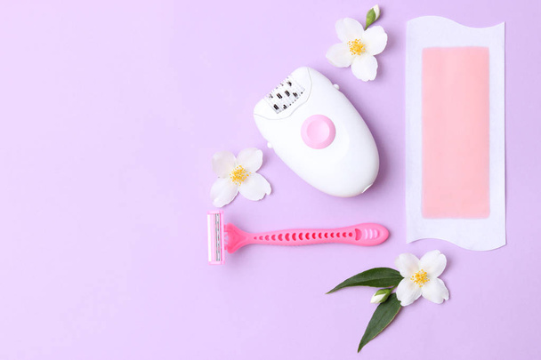 a set of different means for epilation on a colored background. Removal of unwanted hair. Modern epilator, wax strips, razor. Minimalism, top view. flatlay  - Valokuva, kuva