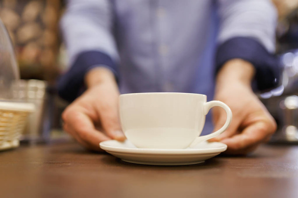 Image of barist man with cup of coffee - Фото, зображення
