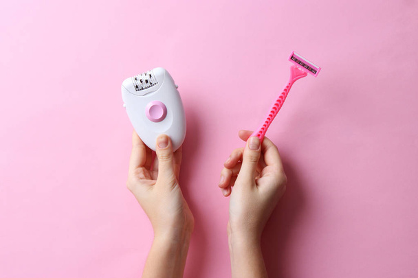 a modern epilator and a razor in female hands. choice. removal of unwanted hair. smooth skin - Fotó, kép
