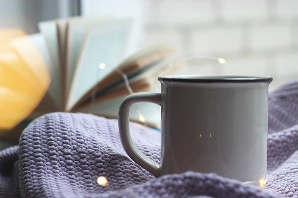 a garland, a cup, a plaid and a book on the windowsill. minimalism, top, insta - Photo, Image