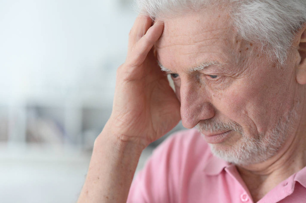 Senior man with headache at home - Fotoğraf, Görsel