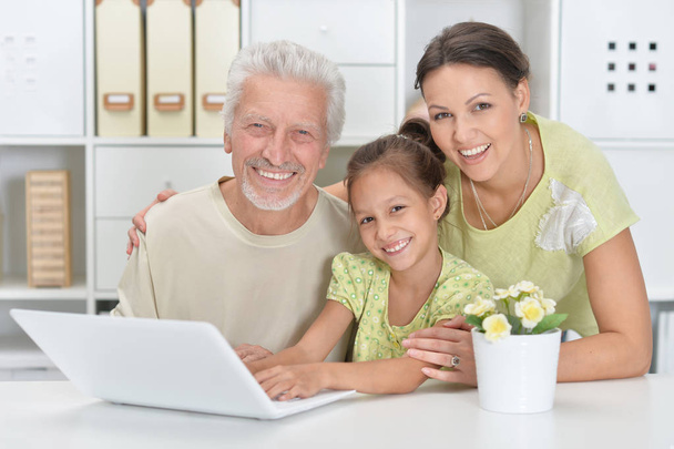 Grandfather, daughter and granddaughter using laptop together - Fotografie, Obrázek