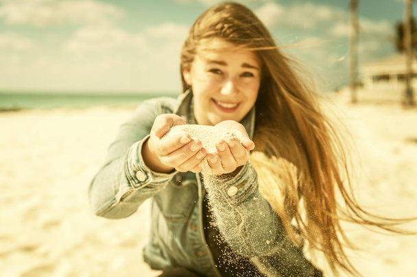 retrato de joven hermosa mujer en la relajación en la playa tropical de con la arena en la mano - Foto, imagen