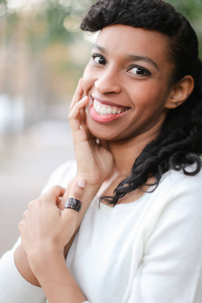 Portrait of beautiful afro american female person with ponytail and ring smiling with white teeth. - Photo, Image