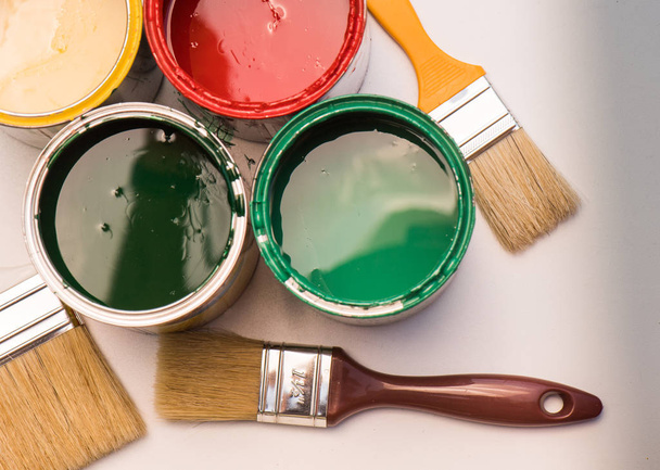 Pinceles y latas de pintura abiertas con colores
 - Foto, Imagen