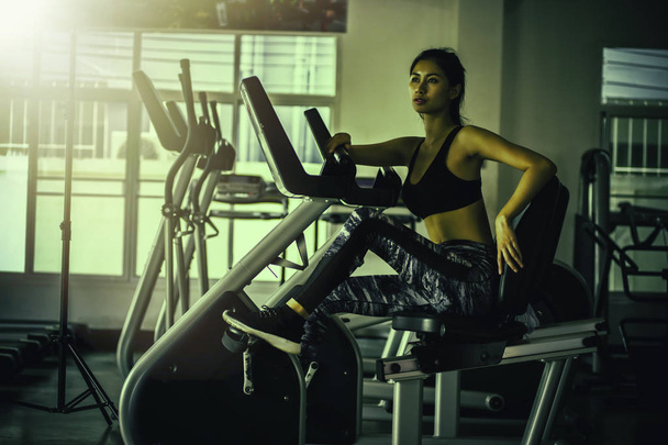 spor yaparken Asya genç kadınlar için fitness salonunda bisikleti - Fotoğraf, Görsel