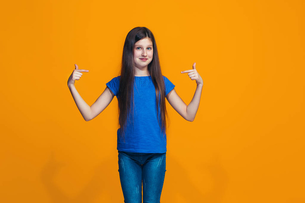 The happy teen girl standing and smiling against pink background. - Foto, Imagen