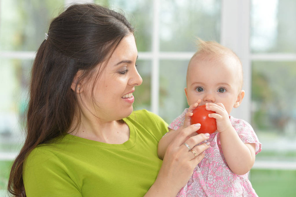 young woman with  baby girl with tomato - Foto, Imagem