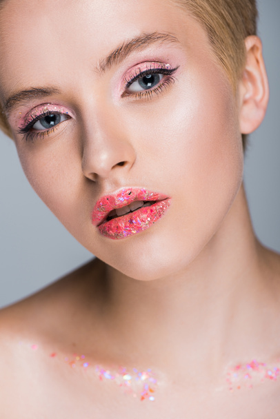 attractive woman with sequins on lips looking at camera isolated on grey - Foto, Imagem