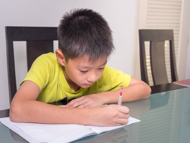 Asie studentík chlapce studovat a dělat domácí úkoly doma, na stole, domácí vzdělávání - Fotografie, Obrázek