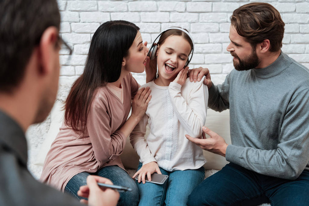 Frustrated parents trying reaching out to little girl in headphones, consultation with family psychologist - Valokuva, kuva
