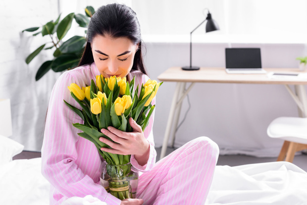portrait of tender woman with bouquet of yellow tulips at home - Photo, Image